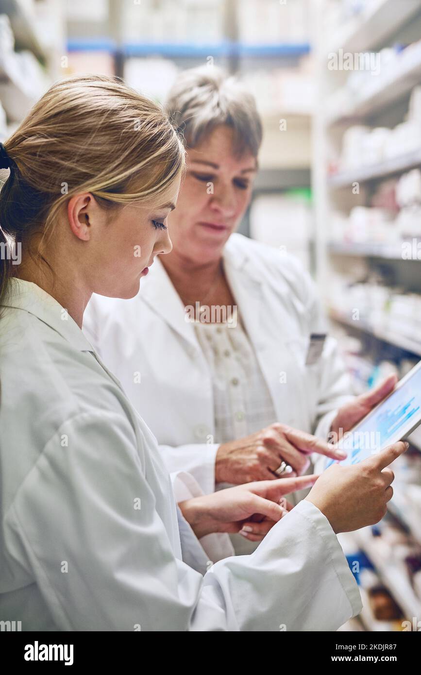 They go the extra mile. pharmacists using a digital tablet together