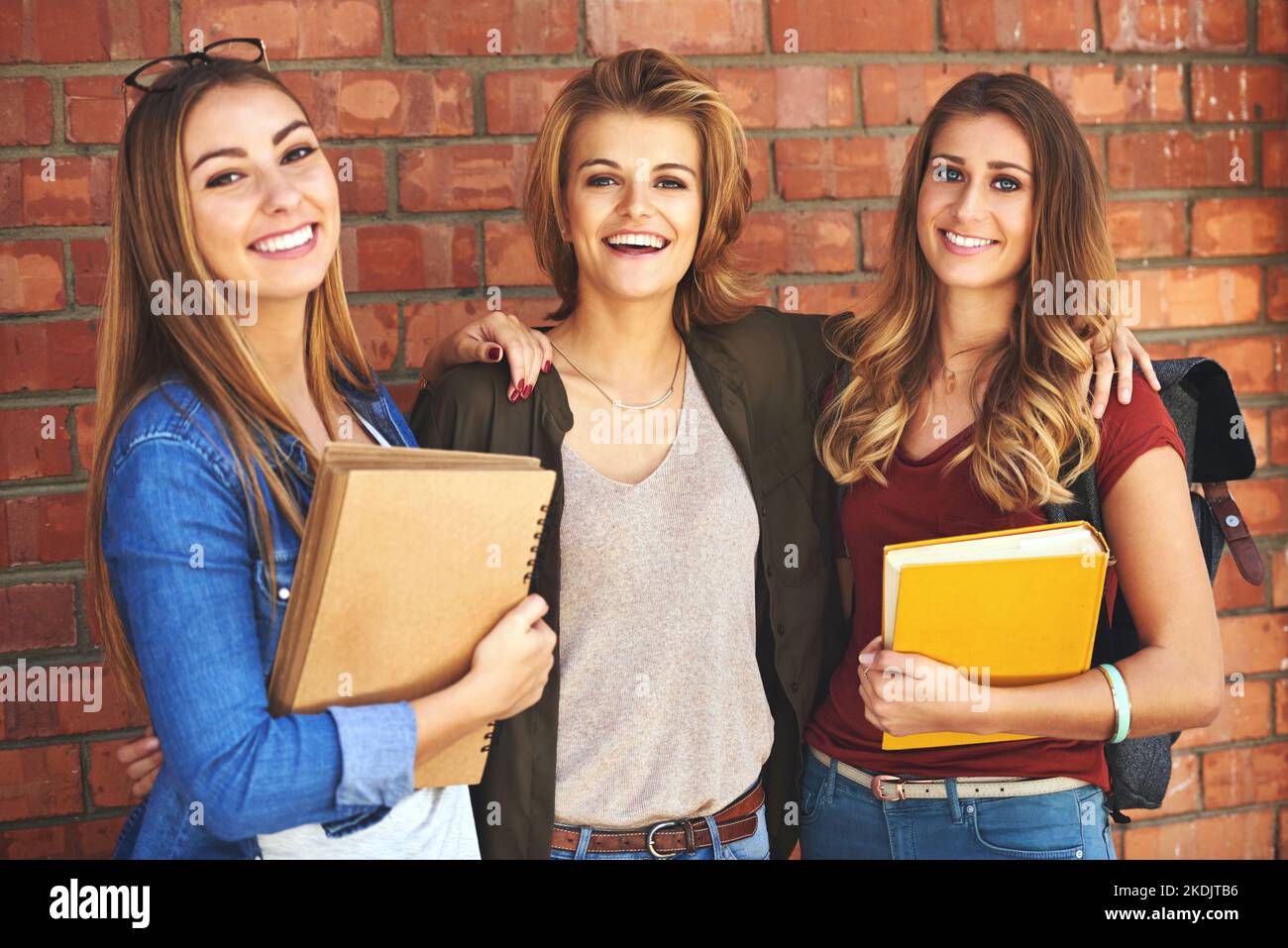Their friendship will last long after college. Portrait of a group of smiling female university students standing together on campus. Stock Photo