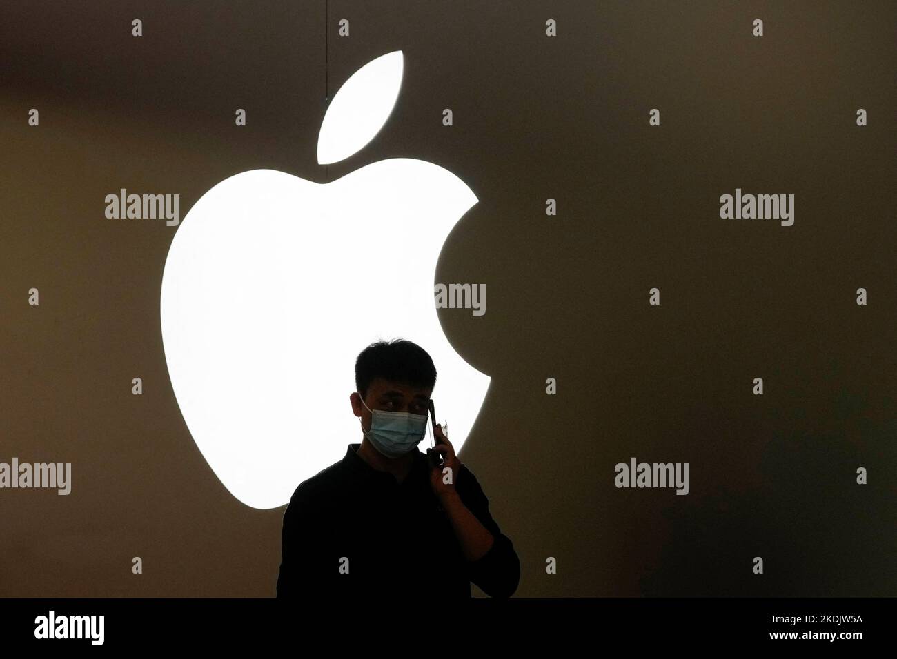 A man talks on a phone in front of an Apple logo outside its store, following the coronavirus disease (COVID-19) outbreak in Shanghai, China, November 7, 2022. REUTERS/Aly Song Stock Photo