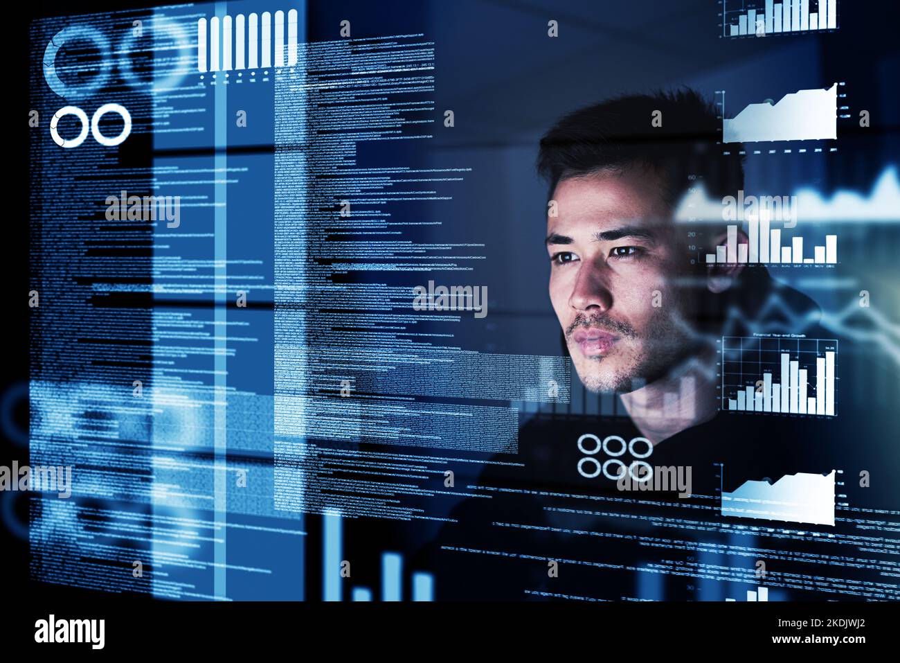Programming requires razor-sharp focus. a focussed computer programmer working at his computer late at night. Stock Photo