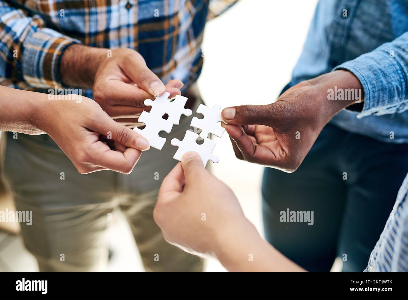 The solution is in the hands of the team. a work group connecting pieces of a puzzle. Stock Photo