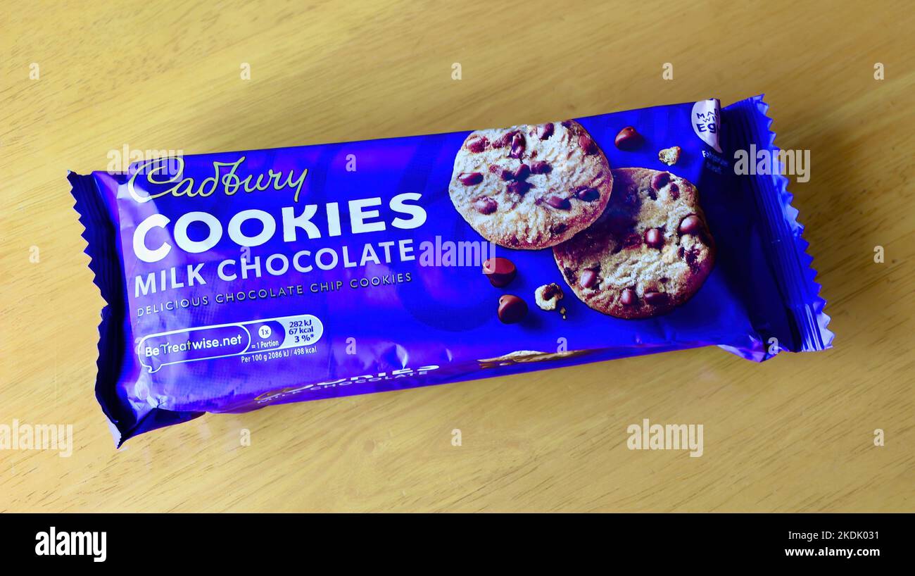 Packet of Cadbury milk chocolate cookies with plastic wrapper on a wooden table top Stock Photo