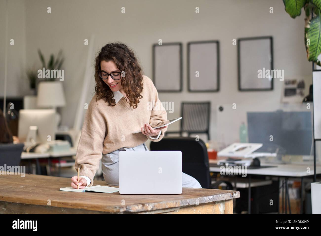 Young smiling busy business woman working in office using digital tablet. Stock Photo