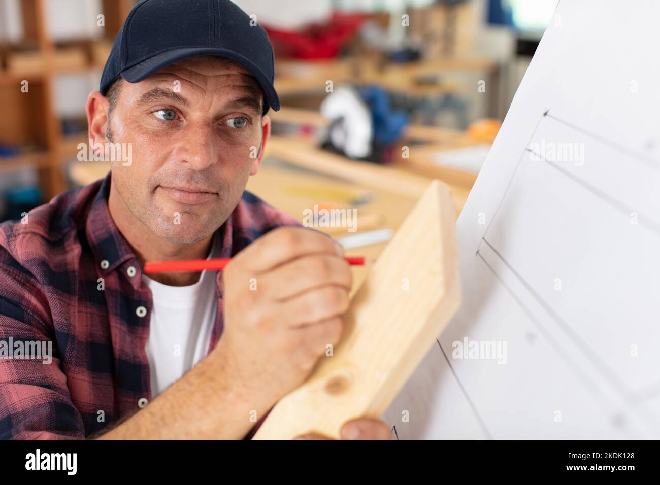 professional carpenter taking measurements at construction site Stock