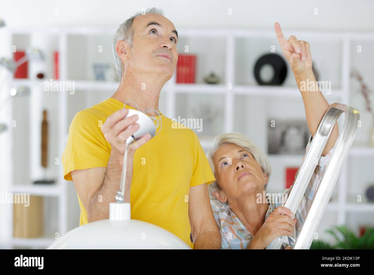 elderly grey-haired couple repairs lamp under ceiling Stock Photo - Alamy