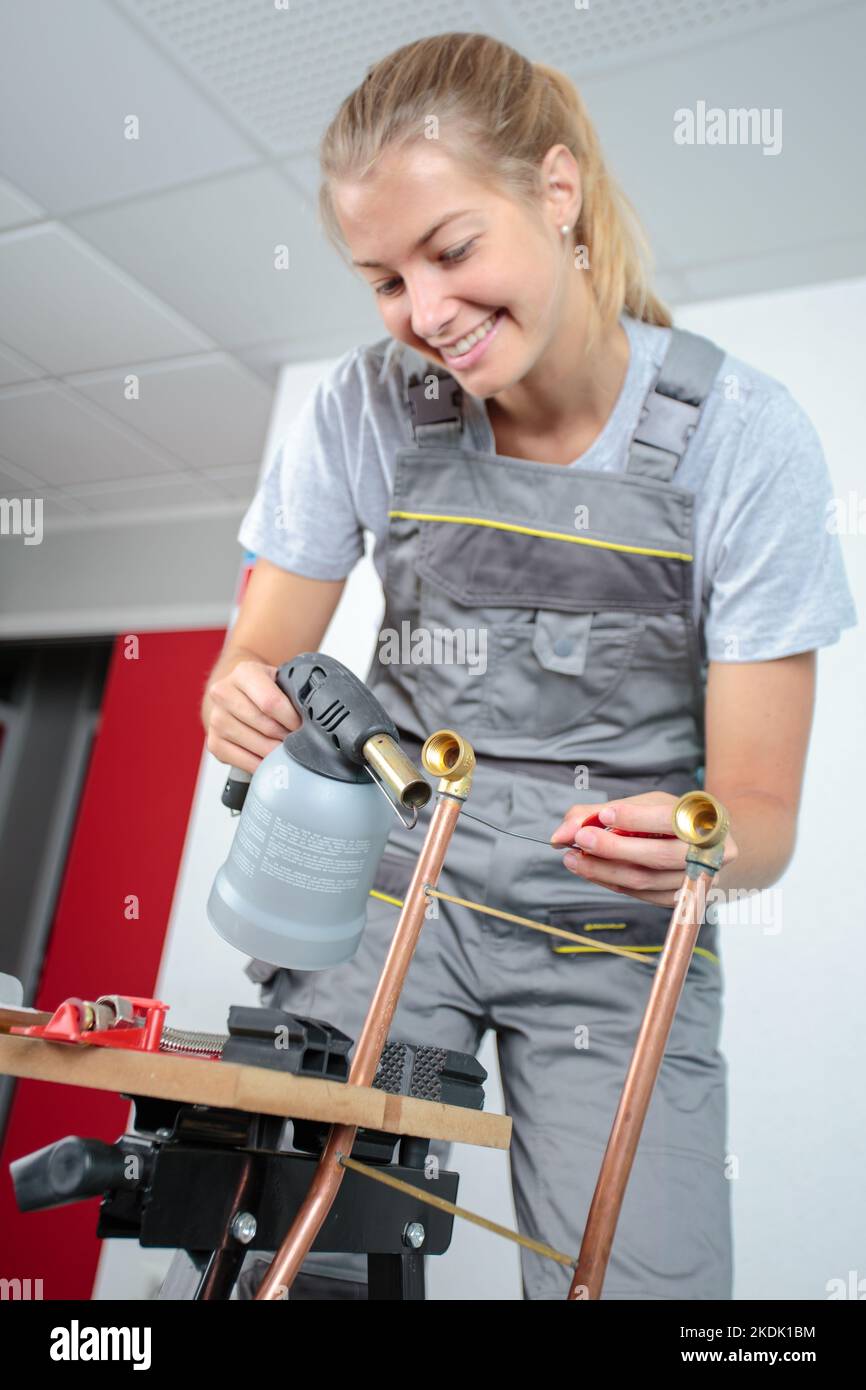 woman soldering cooper pipe with a blowtorch Stock Photo Alamy