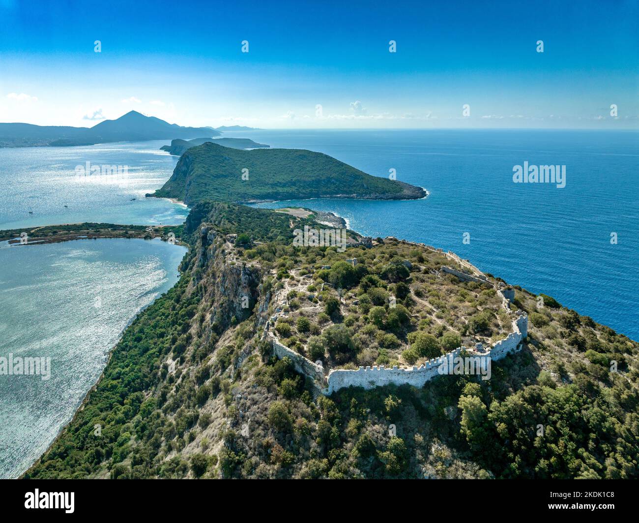 Aerial view of Voidokilia Navarino beach, crescent shape turquoise lagoon with ruined Venetian fort above Stock Photo