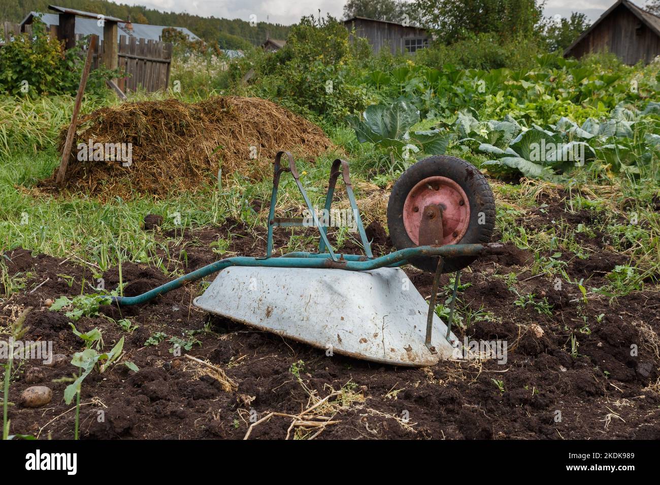 overturned wheelbarrow in the garden. wheelbarrow lying on the ground