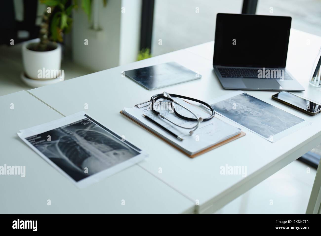 Stethoscope, patient x ray film, important documents and computer on doctor's desk Stock Photo