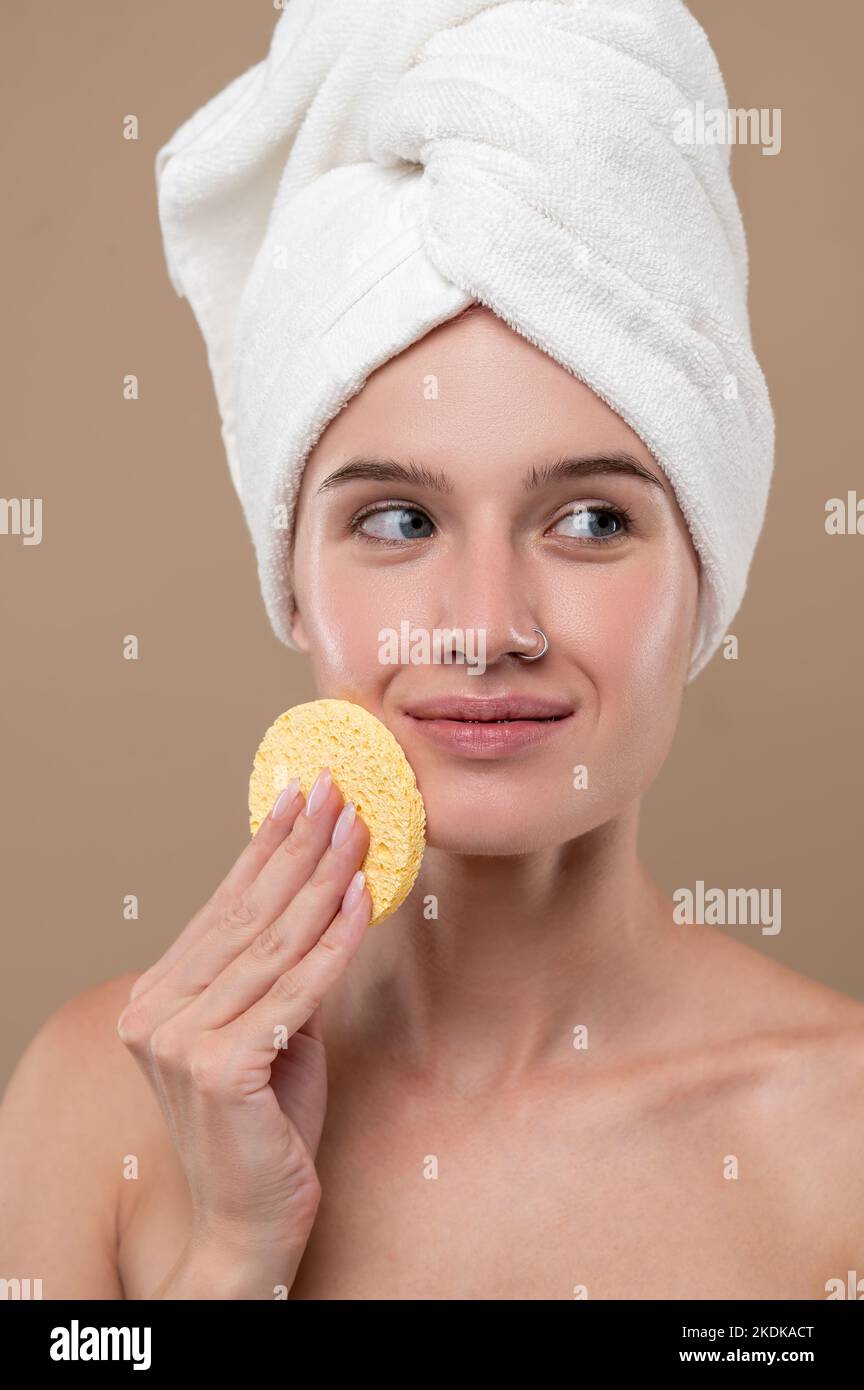 Pretty young girl cleaning her face with a sponge Stock Photo Alamy