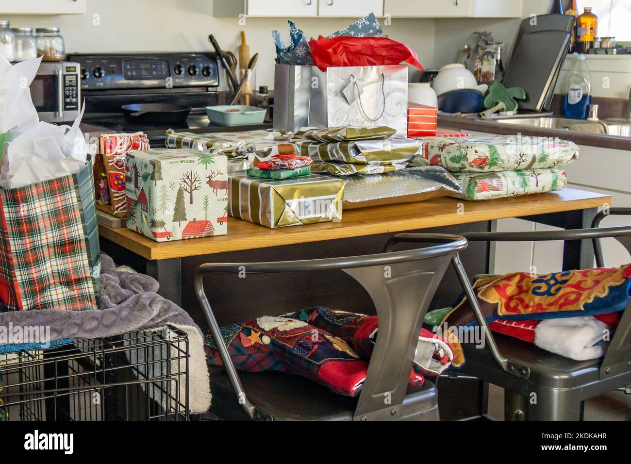 Christmas presents on an island in a cluttered kitchen. Stock Photo