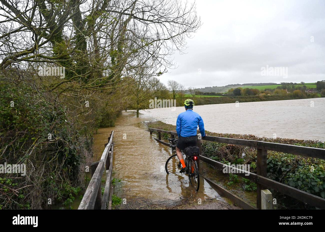 Alfriston East Sussex UK 7th November 2022 - A cyclist finds his way blocked by floodwater from the Cuckmere River  in Alfriston , East Sussex after heavy rain with more forecast to spread across Britain over the next few days : Credit Simon Dack / Alamy Live News Stock Photo