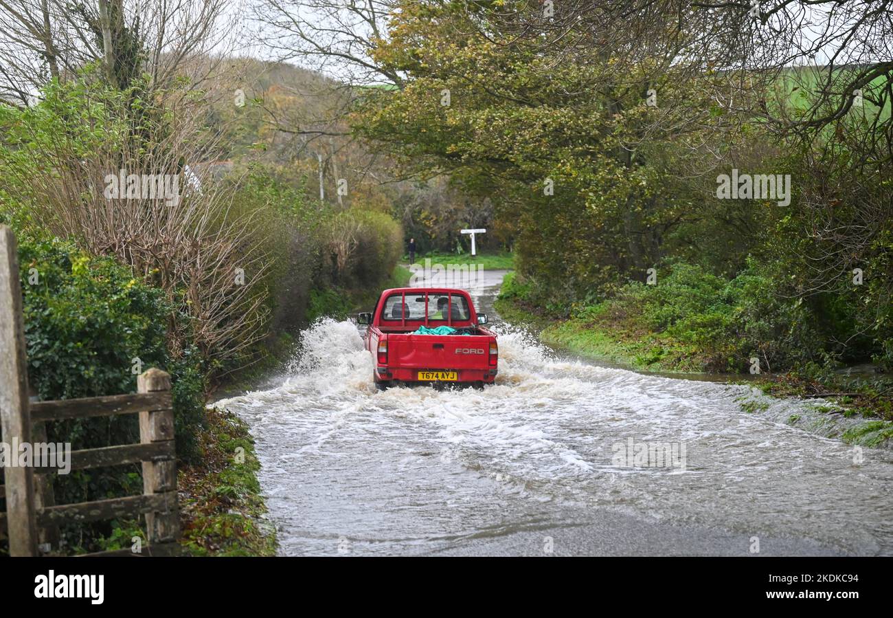 Alfriston East Sussex UK 7th November 2022 - A farm vehicle drives through a flooded lane in Alfriston village in East Sussex after more heavy rain which is forecast to continue across Britain over the next few days : Credit Simon Dack / Alamy Live News Stock Photo
