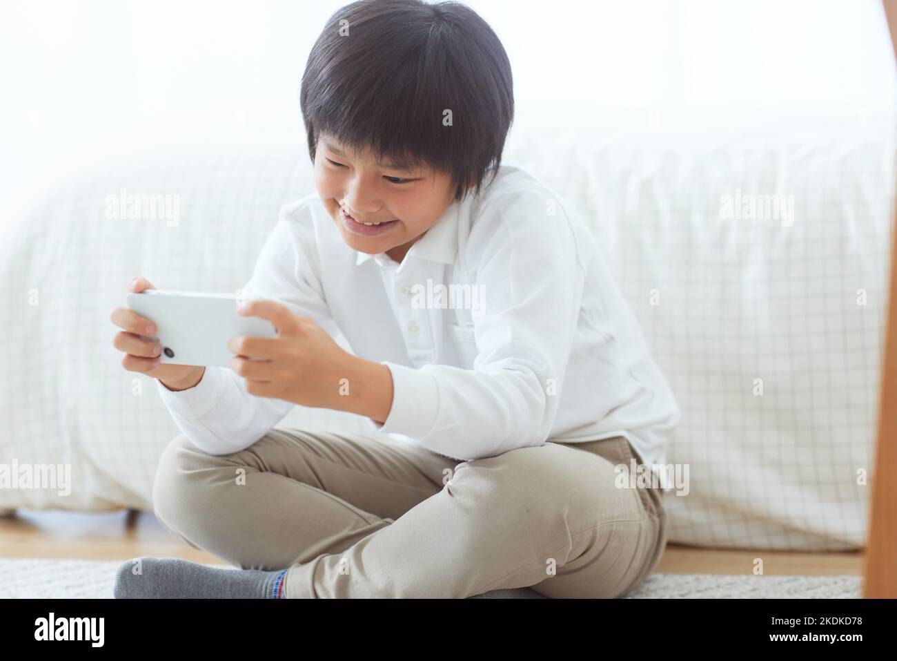 Japanese kid using smartphone at home Stock Photo