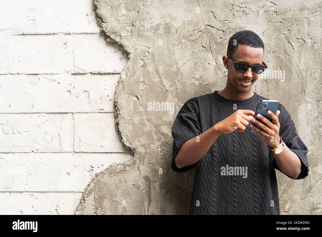 Handsome young African man using mobile phone outdoors Stock Photo