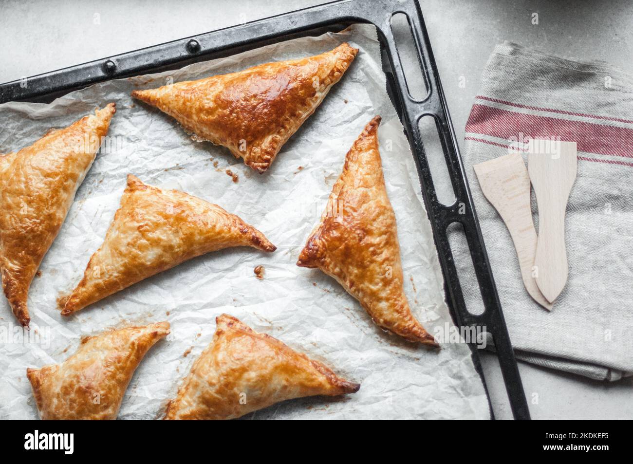 Baked pies in the form of triangles from puff pastry Stock Photo - Alamy
