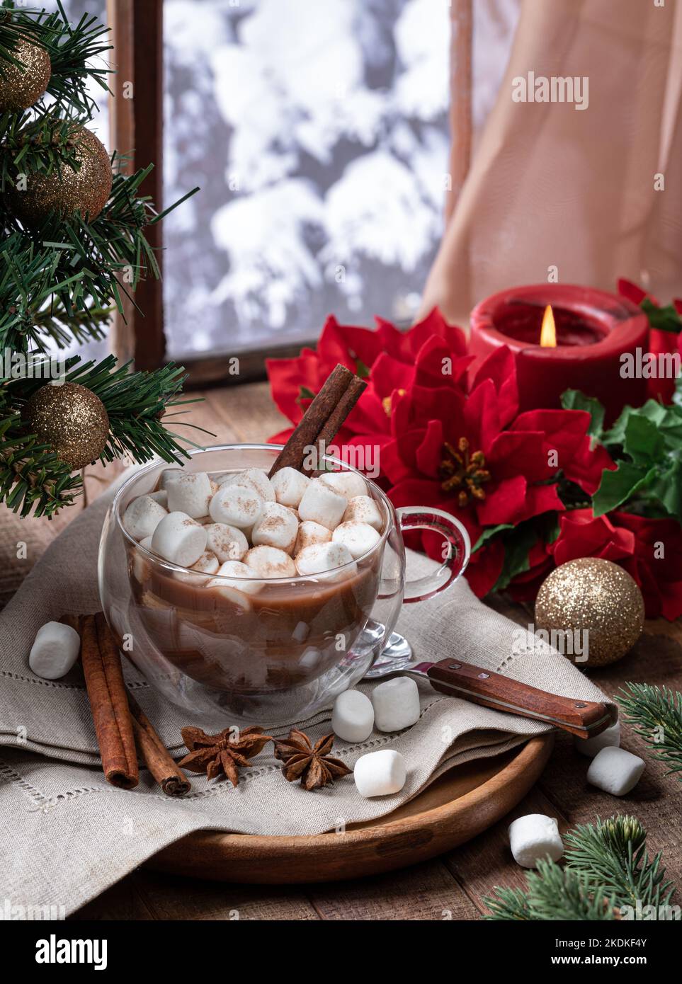 https://c8.alamy.com/comp/2KDKF4Y/cup-of-hot-chocolate-with-marshmallows-and-cinnamon-with-holiday-decorations-on-a-wooden-table-by-a-window-with-winter-background-2KDKF4Y.jpg