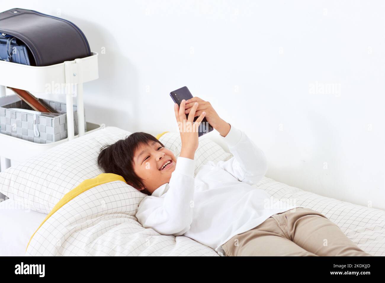 Japanese kid using smartphone at home Stock Photo