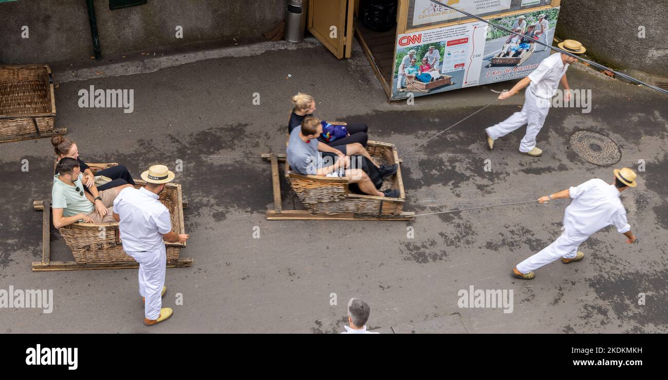 Tourists taken for a ride in traditional wooden toboggans at Monte
