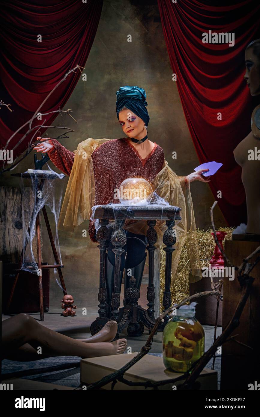 Portrait of magnificent fortune teller woman reading future on magical