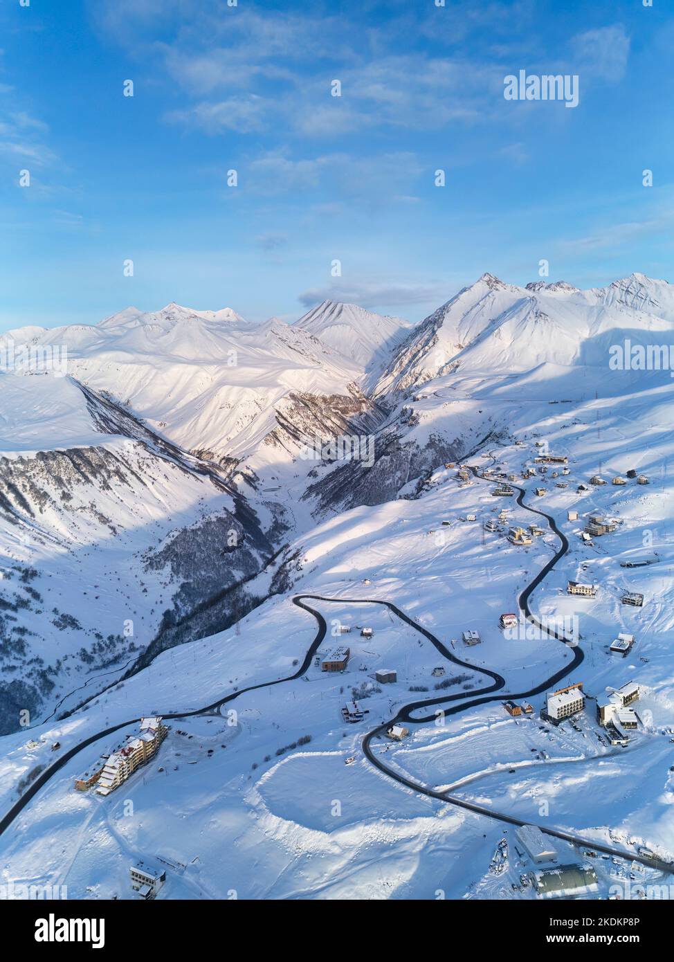 Aerial of snowy mountain range on winter sunrise at ski resort. Drone ...