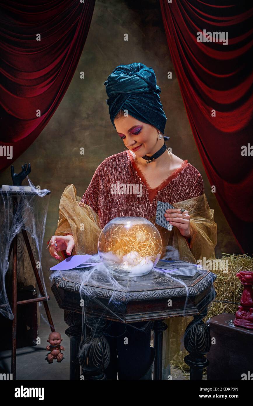 Portrait of magnificent fortune teller woman reading future on magical