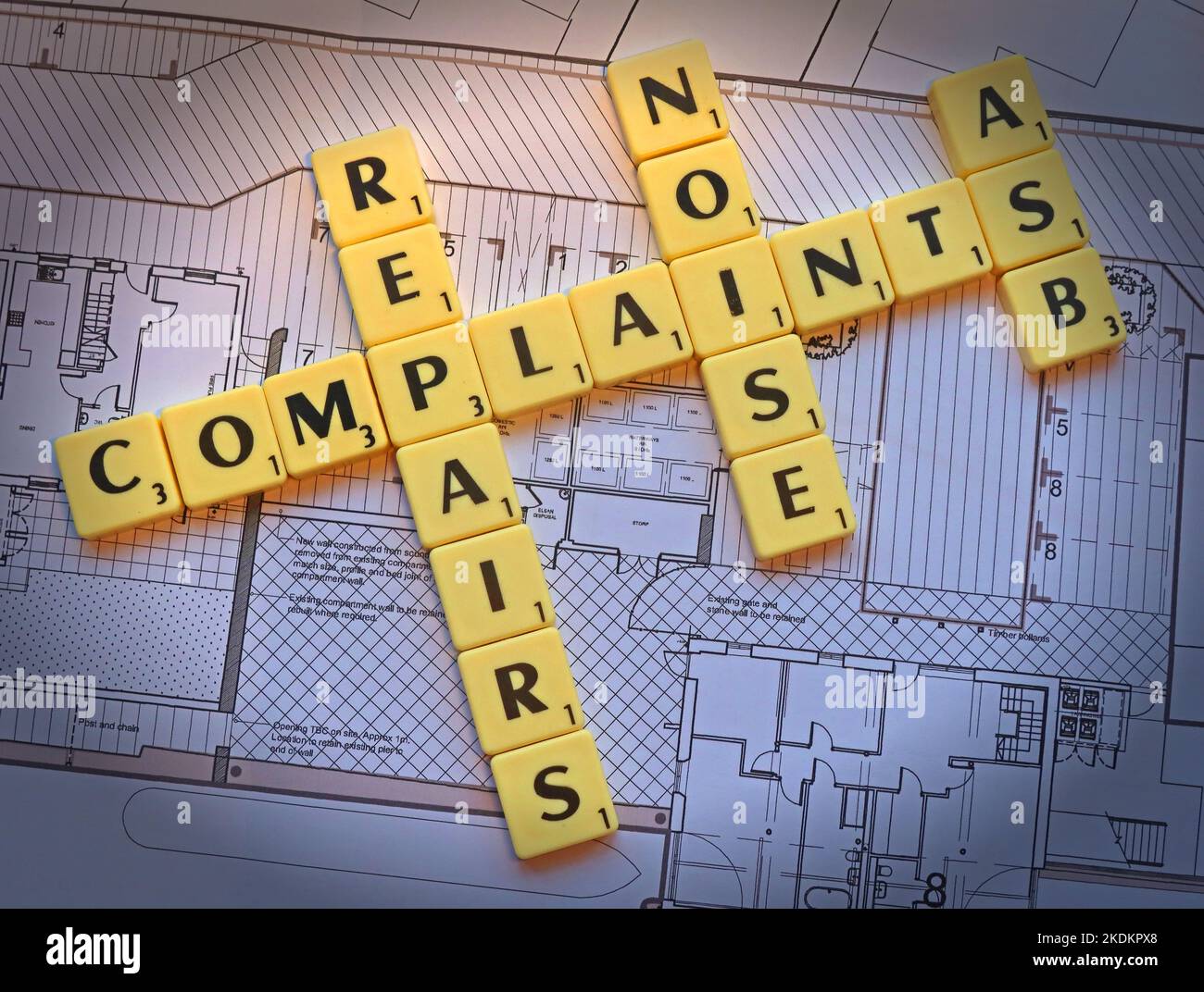 All types of complaint - Repairs,ASB, Noise - Scrabble letters on plans for a housing scheme - Property Issues Stock Photo
