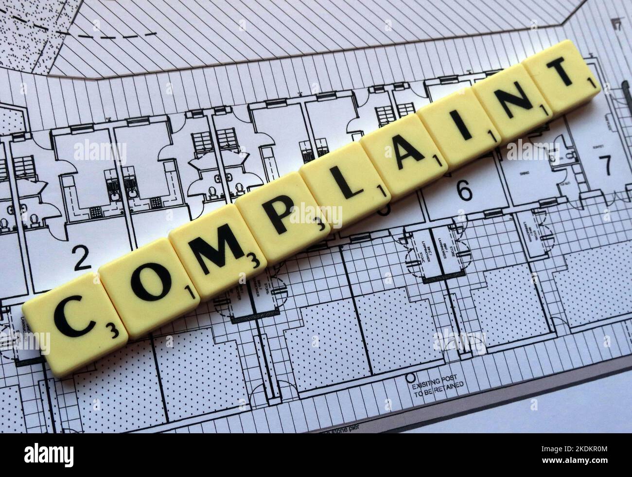 Property or service complaint - Scrabble letters on plans for a housing scheme - Property Issues Stock Photo