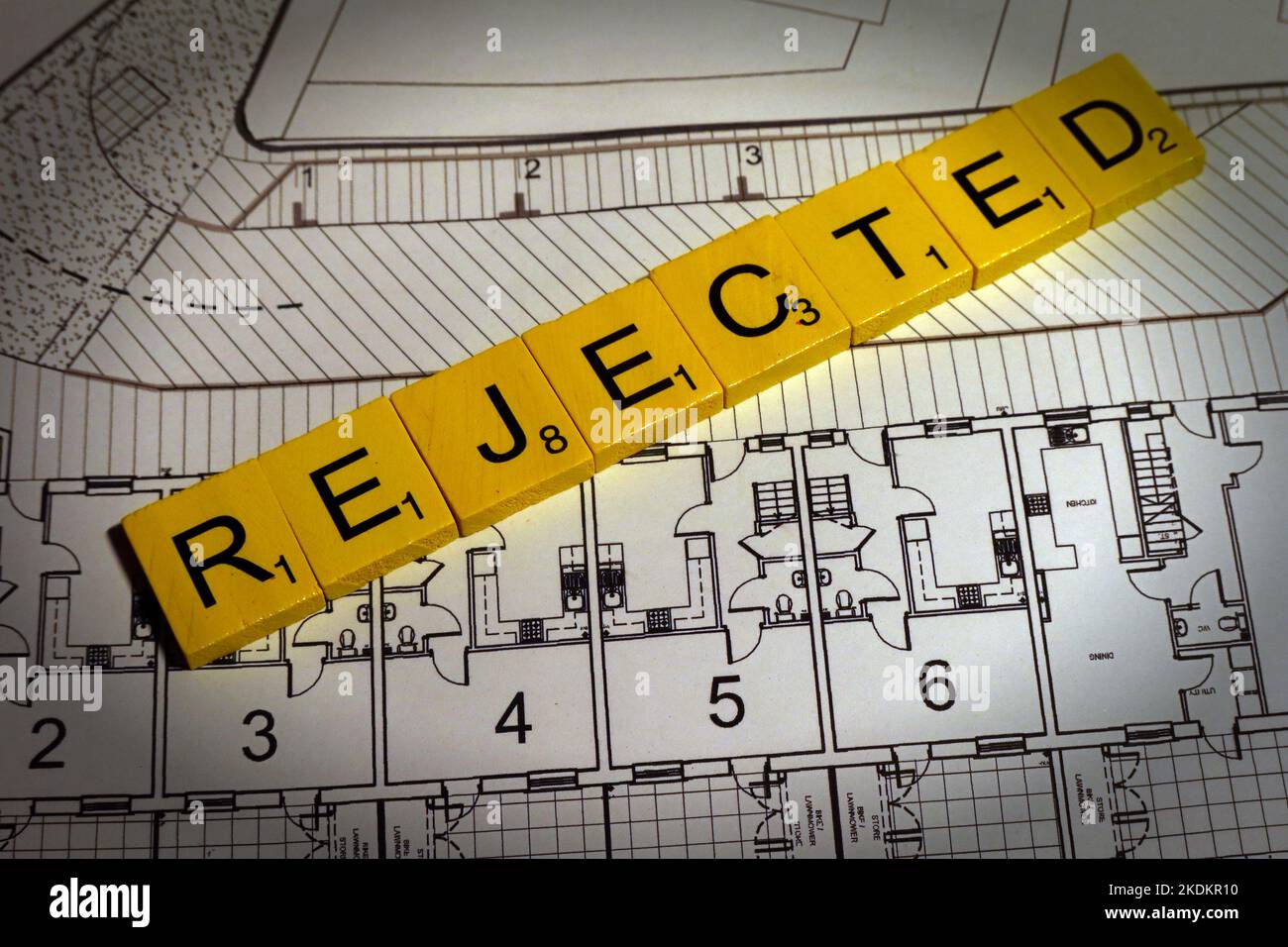 Scheme / planning rejected - Scrabble letters on plans for a housing scheme - Property Issues Stock Photo