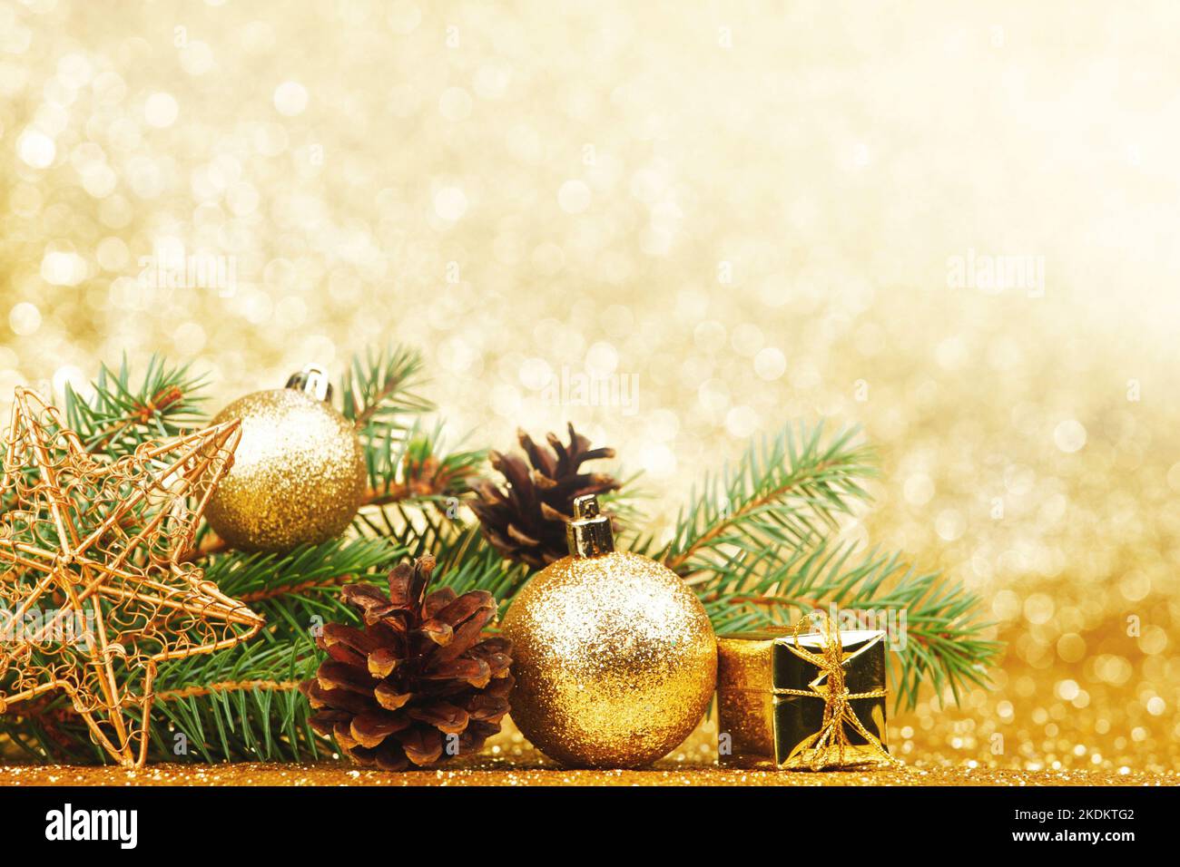 Christmas card with fir branch and decorations on golden gitter ...