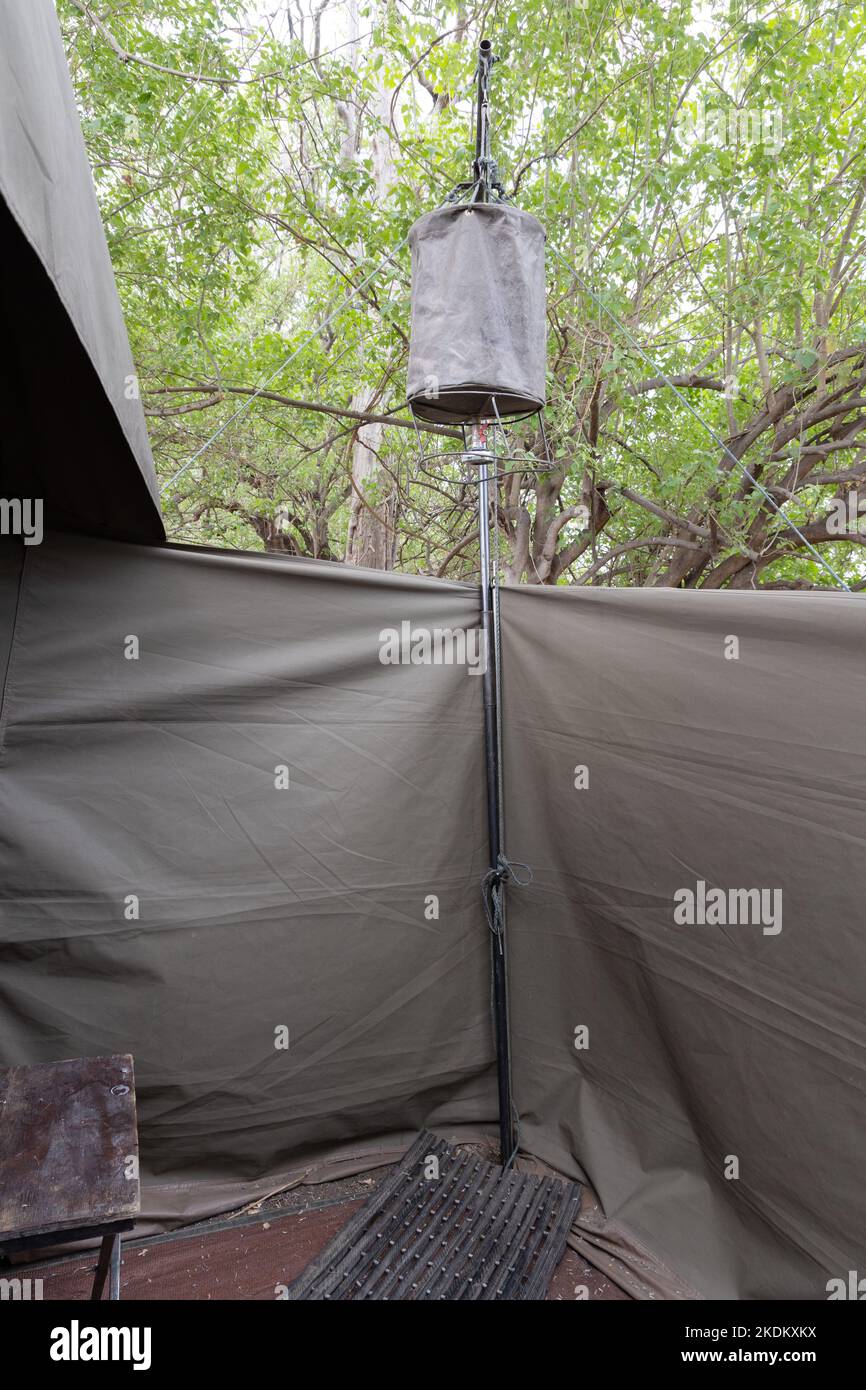 A basic safari shower at the back of a temporary mobile tent on a tented safari holiday, Okavango Delta, Botswana Africa Stock Photo