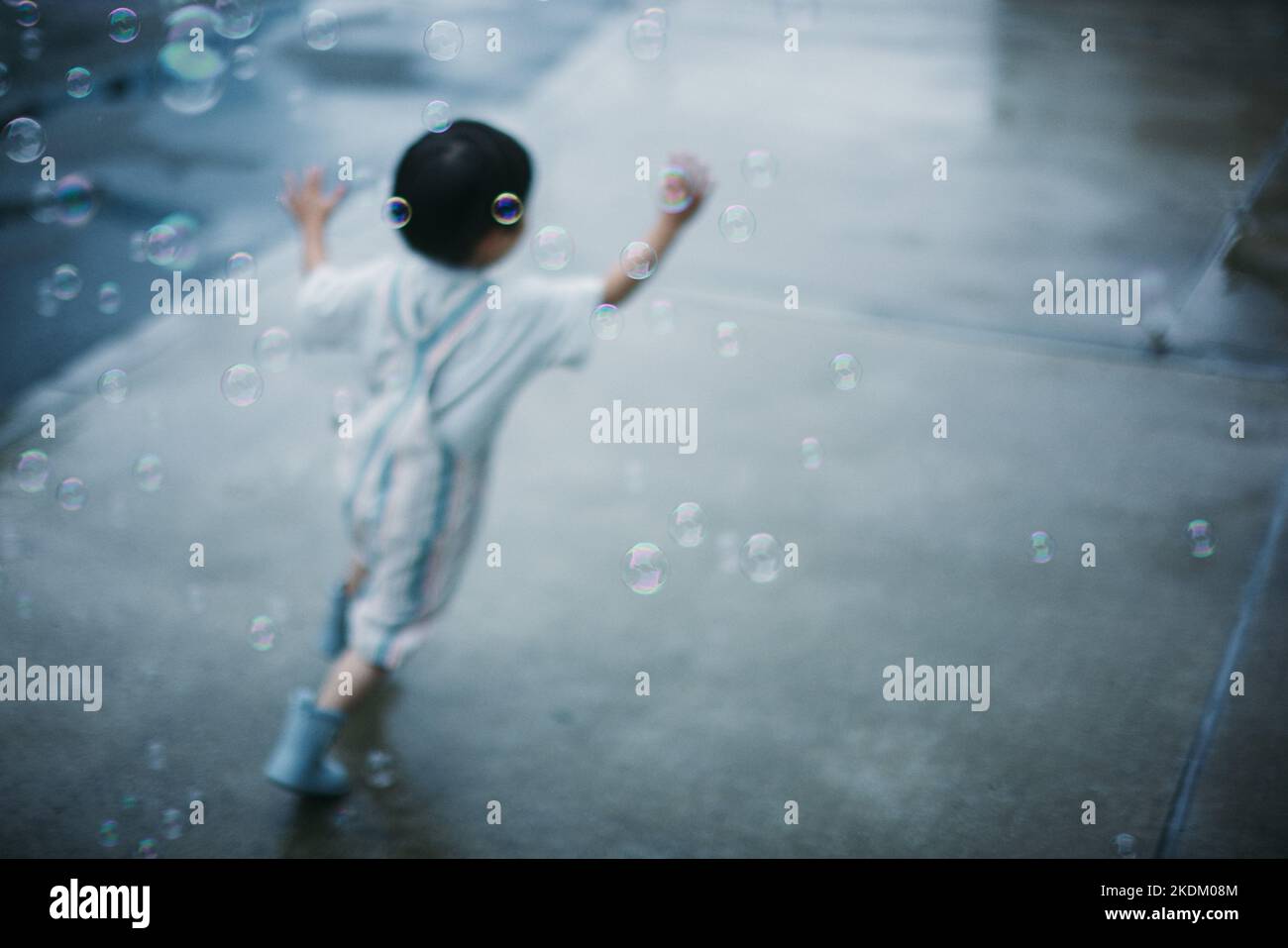 Japanese kid playing outside on a rainy day Stock Photo
