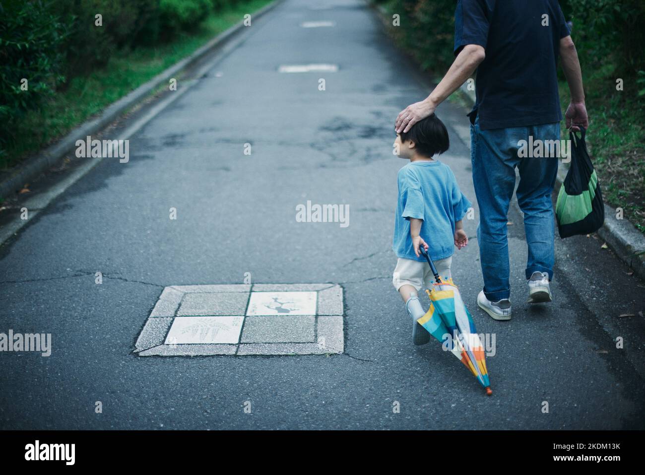 Japanese kid playing outside on a rainy day Stock Photo