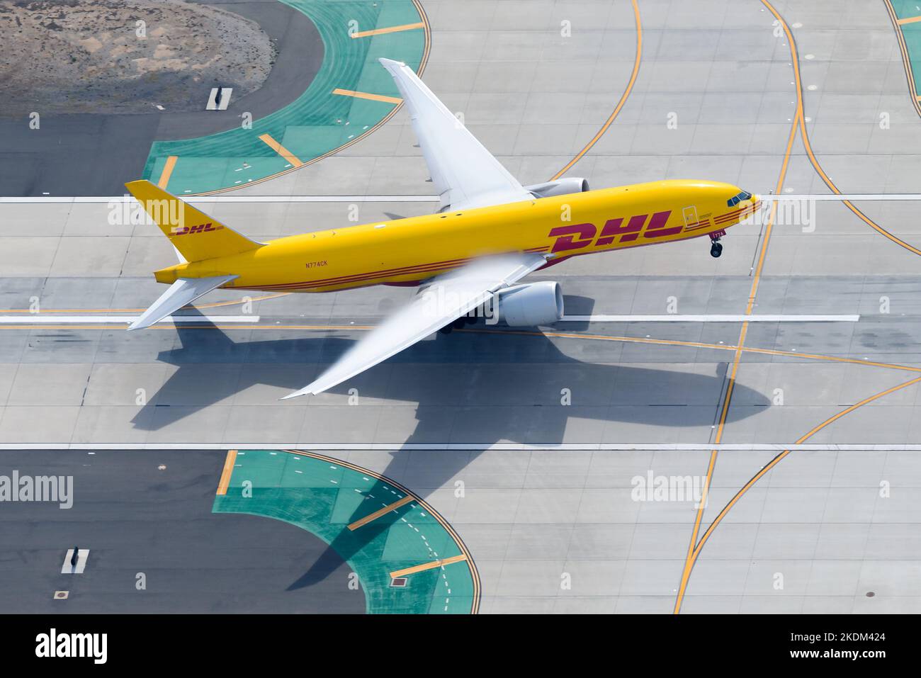 DHL Cargo airplane Boeing 777 taking off. Transport of freighter on DHL Kalitta Air aircraft 777F. Aircraft take off with condensation above wings. Stock Photo