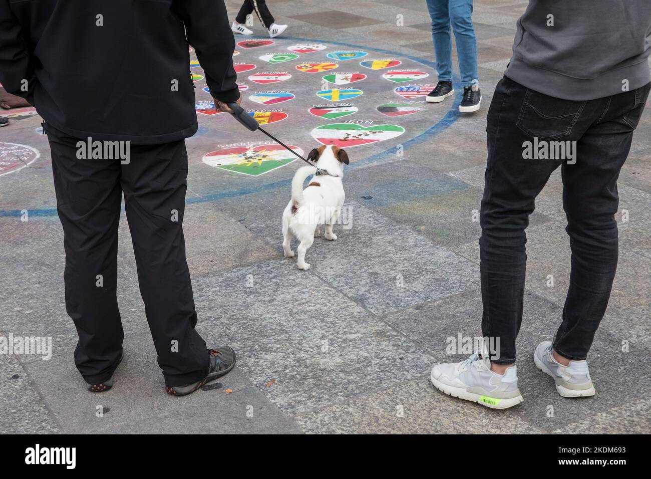 painting of a pavement painter in front of the cathedral, flags of various countries, passer-by with dog, Cologne, Germany. Pflastermaler vor dem Dom, Stock Photo