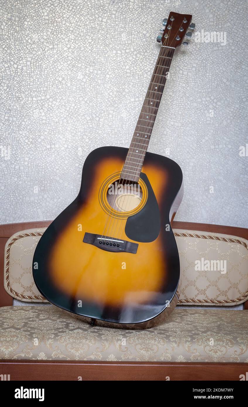 Beautiful classical sevenstring guitar on a small sofa against the