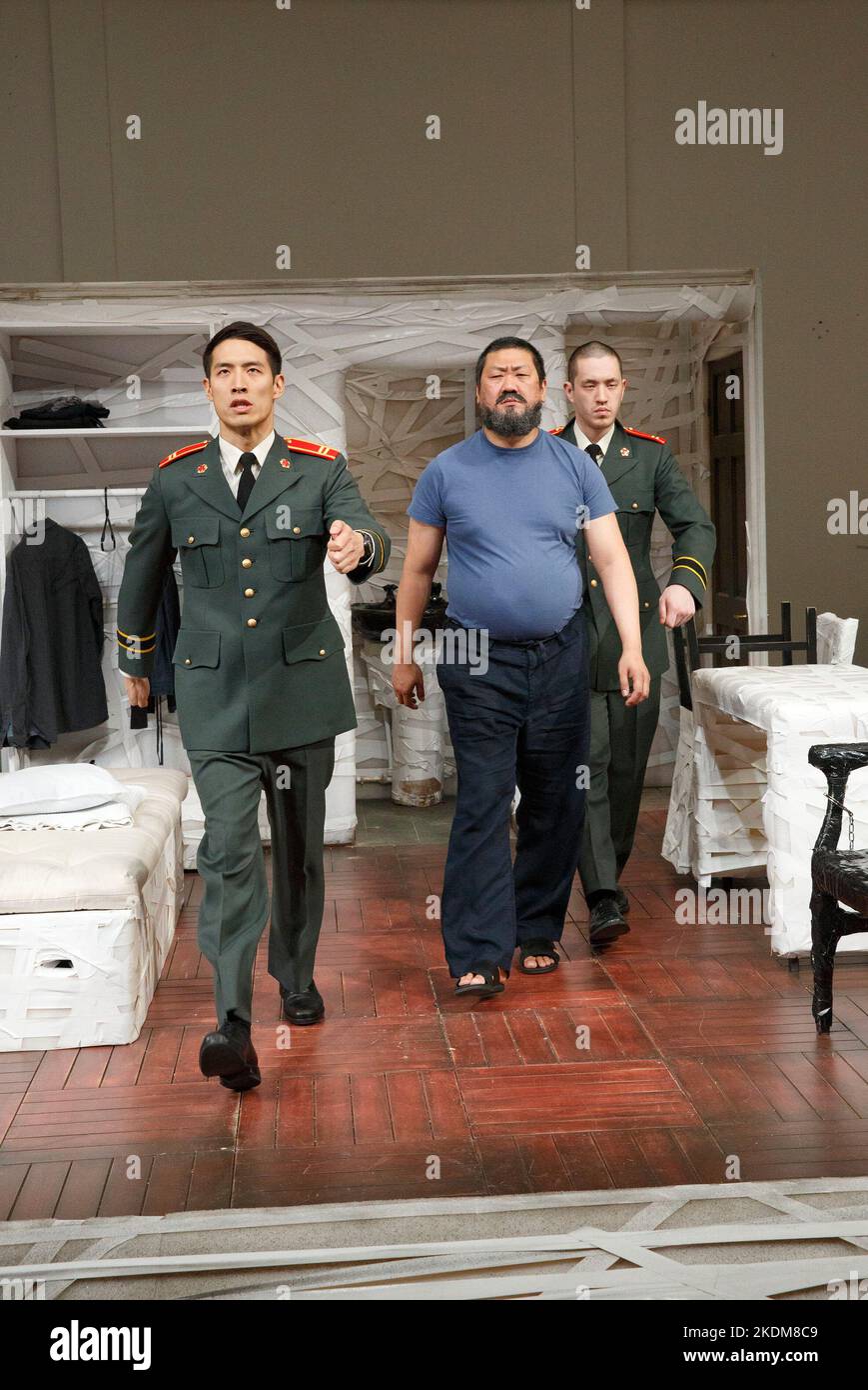 repetitive marching - l-r: Christopher Goh (2nd Soldier), Benedict Wong (Ai Weiwei), Andrew Koji (1st Soldier) in #aiww: THE ARREST OF AI WEIWEI by Howard Brenton at the Hampstead Theatre, London NW3  17/04/2013 design: Ashley Martin Davis   lighting: Matthew Richardson   director: James Macdonald Stock Photo