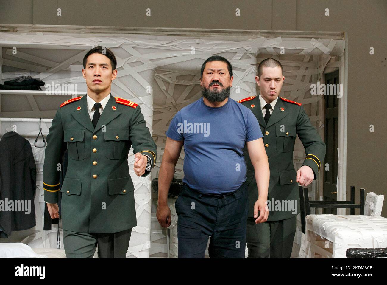 repetitive marching - l-r: Christopher Goh (2nd Soldier), Benedict Wong (Ai Weiwei), Andrew Koji (1st Soldier) in #aiww: THE ARREST OF AI WEIWEI by Howard Brenton at the Hampstead Theatre, London NW3  17/04/2013 design: Ashley Martin Davis   lighting: Matthew Richardson   director: James Macdonald Stock Photo