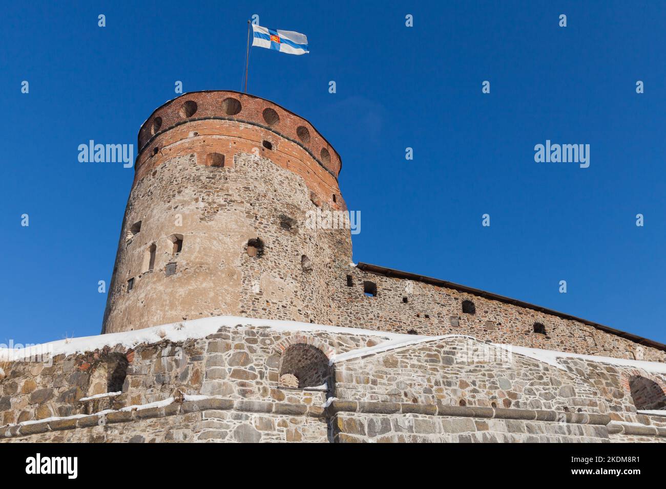 Round tower of Olavinlinna is under blue sky on a sunny day. It is a 15th-century three-tower castle located in Savonlinna, Finland. The fortress was Stock Photo
