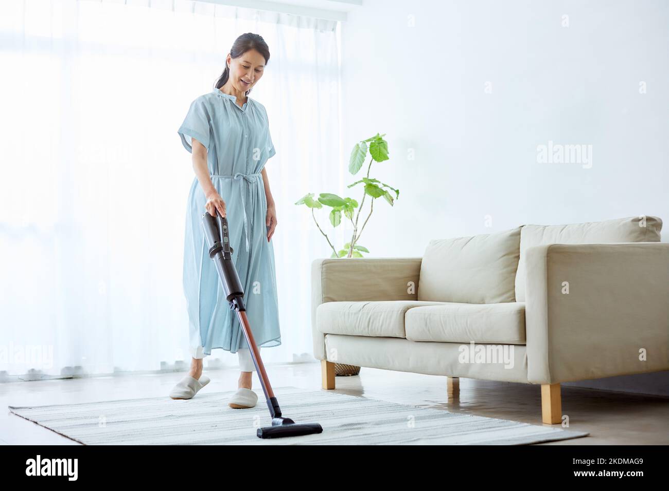 Male worker removing dirty stain from grey sofa with vacuum cleaner in room  Stock Photo - Alamy