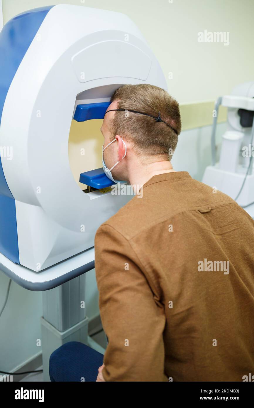 Professional medical equipment scanning the patient's eyes. The device