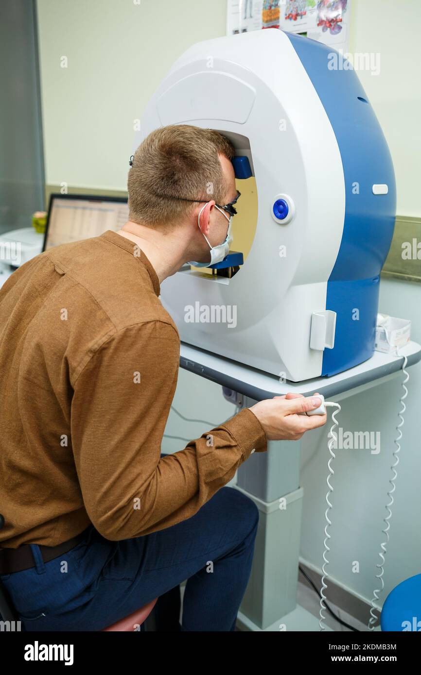 Professional medical equipment scanning the patient's eyes. The device
