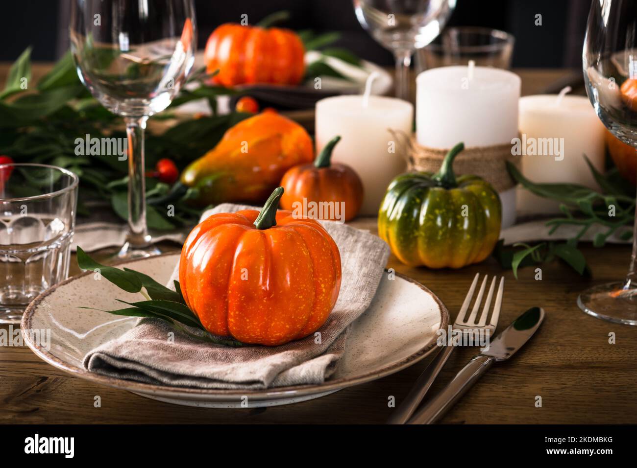 Autumn table setting with plate, pumpkin and candles Stock Photo - Alamy