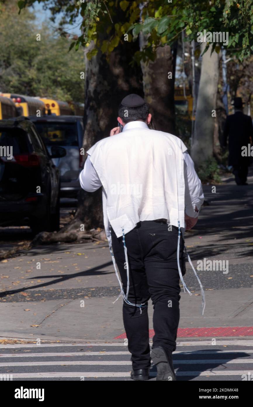 An anonymous orthodox Jewish man wearing his tallis katan tzitzit over his shirt. On a mild autumn day in Brooklyn, New York. Stock Photo