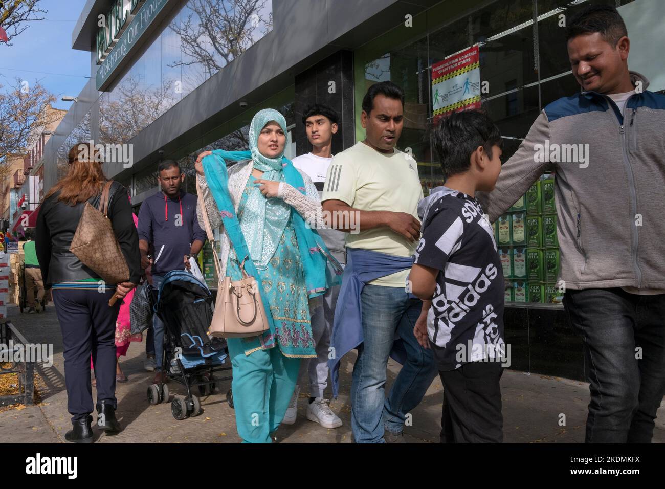 A street scene in Jackson Heights with a variety of ages, ethnicities and attire. On 74th Street in Queens, New York. Stock Photo