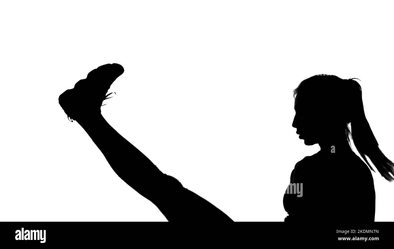 on a white background, a shadow, a black outline of a female figure doing boxing movements, a fight with a shadow, kicking, kickboxing, imitations of blows, combat techniques,. High quality photo Stock Photo
