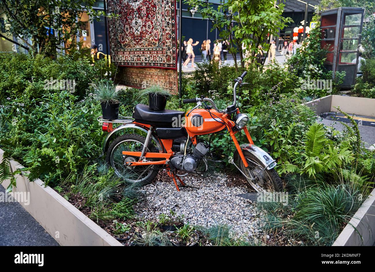 Moscow, Russia - 30.07.2022: A Soviet orange motorcycle standing among green plants Stock Photo