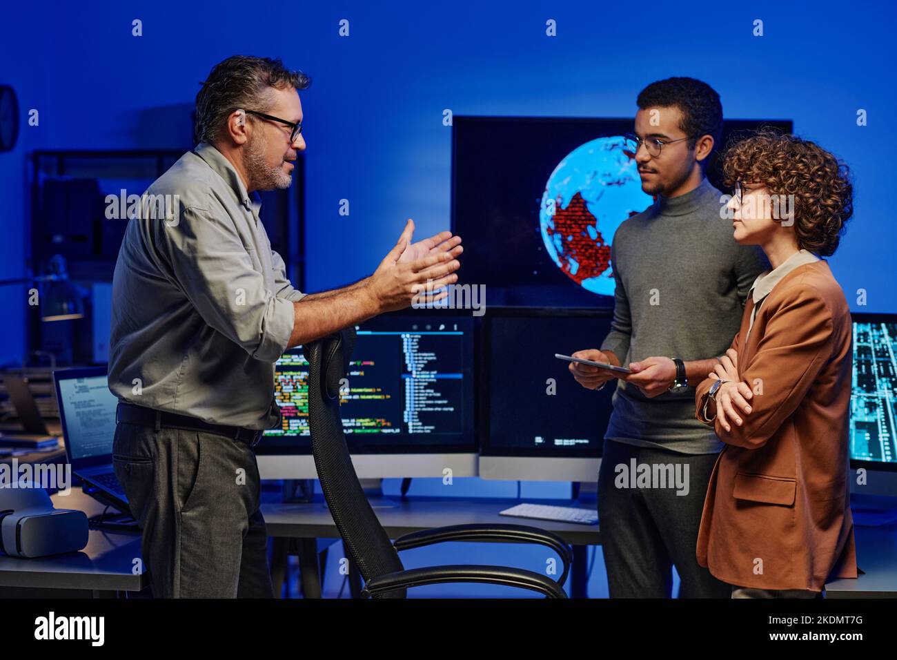 Side view of confident mature boss giving working instructions to young