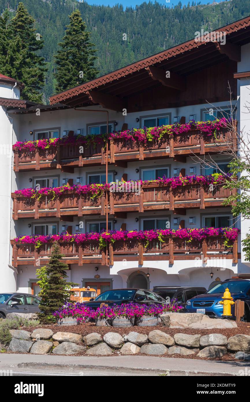 Balconies of a Bavarain style hotel in Leavenworth, Washington, USA overflow with flower boxes of purple petunias and pea vines. Stock Photo