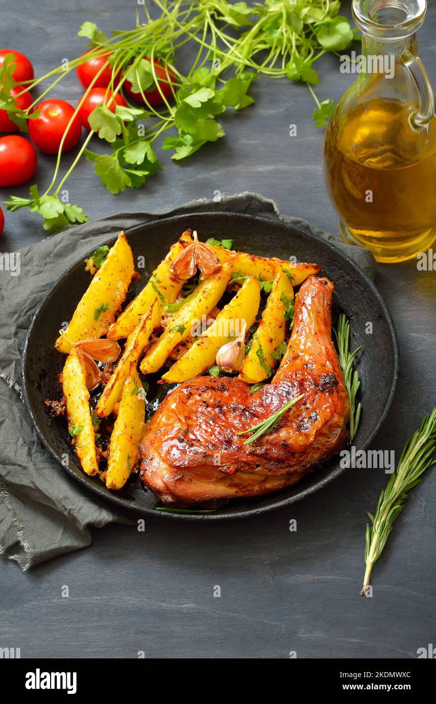 Fried chicken leg and potato wedges on plate Stock Photo